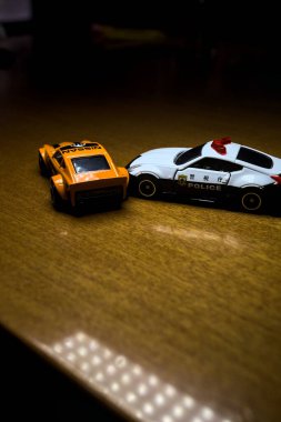 Mantova, İtalya - 29 Nisan 2025 - 1 / 64 Hot Wheels and Takara Tomi replicas of a orange Nissan Fairlady Z and a Nissan Fairlady Z Nismo Japanese police car simulating a ramming