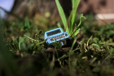 Mantova, İtalya - 1. Mart 2025 - 1 / 64 Kibrit kutusu kopyası 1970 Ford Bronco 'nun çimenlerin üzerinde bir çim kavisinin altında tahta bir sopa üzerinde