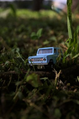 Mantova, İtalya - 1. Mart 2025 - 1 / 64 Kibrit kutusu kopyası 1970 Ford Bronco 'nun çimenlerin üzerinde bir çim kavisinin altında tahta bir sopa üzerinde