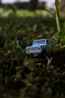 Mantova, İtalya - 1. Mart 2025 - 1 / 64 Kibrit kutusu kopyası 1970 Ford Bronco 'nun çimenlerin üzerinde bir çim kavisinin altında tahta bir sopa üzerinde