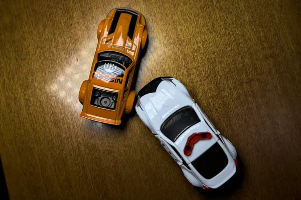 Mantova, İtalya - 29 Nisan 2025 - 1 / 64 Hot Wheels and Takara Tomi replicas of a orange Nissan Fairlady Z and a Nissan Fairlady Z Nismo Japanese police car simulating a ramming