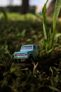 Mantova, İtalya - 1. Mart 2025 - 1 / 64 Kibrit kutusu kopyası 1970 Ford Bronco 'nun çimenlerin üzerinde bir çim kavisinin altında tahta bir sopa üzerinde