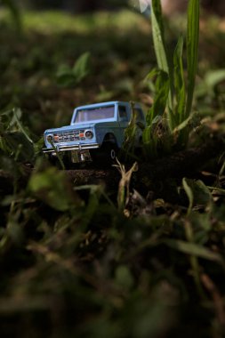 Mantova, İtalya - 1. Mart 2025 - 1 / 64 Kibrit kutusu kopyası 1970 Ford Bronco 'nun çimenlerin üzerinde bir çim kavisinin altında tahta bir sopa üzerinde