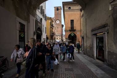 Mantova, İtalya - 8 Mart 2025 - Bulutlu bir günde insanların geçtiği bir pazar günü kemerin altından geçen cadde