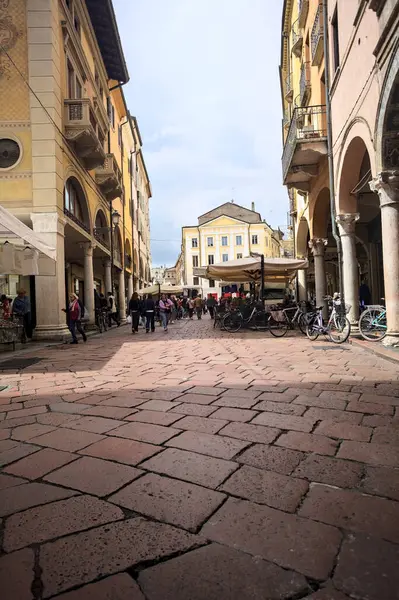 Mantova, İtalya - 8 Mart 2025 - Pazar tezgahları ve bulutlu bir günde kafelerin yanından geçen insanlar