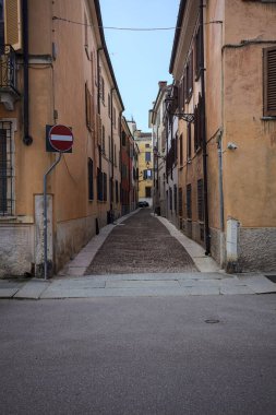 Gölgede dar kaldırımlar ve kenarlarında taş kaldırımlar olan dar bir cadde.