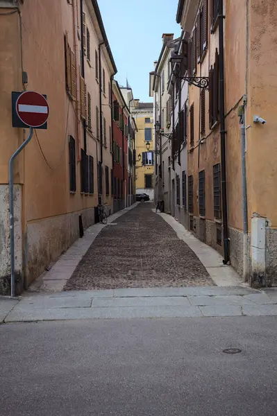 Gölgede dar kaldırımlar ve kenarlarında taş kaldırımlar olan dar bir cadde.