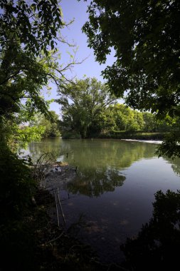 Ağaçların çerçevelediği parktan geçen bir nehrin kıvrımları da suya atılmış.