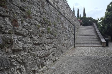 Güneşli bir günde bir kalenin iç duvarına dayanan merdiven.
