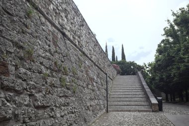 Güneşli bir günde bir kalenin iç duvarına dayanan merdiven.