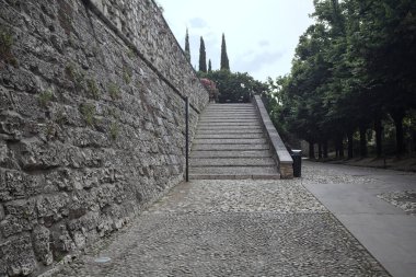 Güneşli bir günde bir kalenin iç duvarına dayanan merdiven.