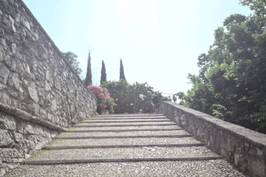 Güneşli bir günde bir kalenin iç duvarına dayanan merdiven.