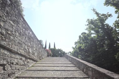 Güneşli bir günde bir kalenin iç duvarına dayanan merdiven.