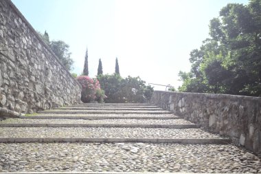 Güneşli bir günde bir kalenin iç duvarına dayanan merdiven.