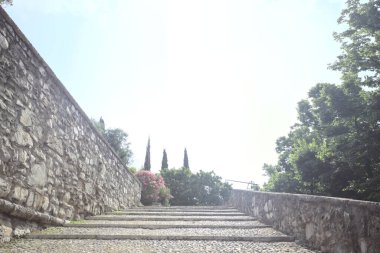 Güneşli bir günde bir kalenin iç duvarına dayanan merdiven.