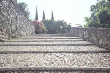 Güneşli bir günde bir kalenin iç duvarına dayanan merdiven.