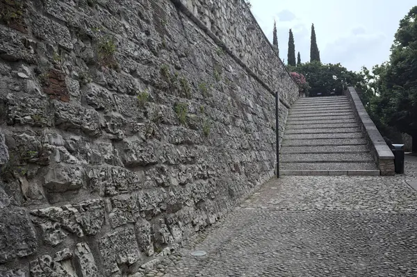 Güneşli bir günde bir kalenin iç duvarına dayanan merdiven.