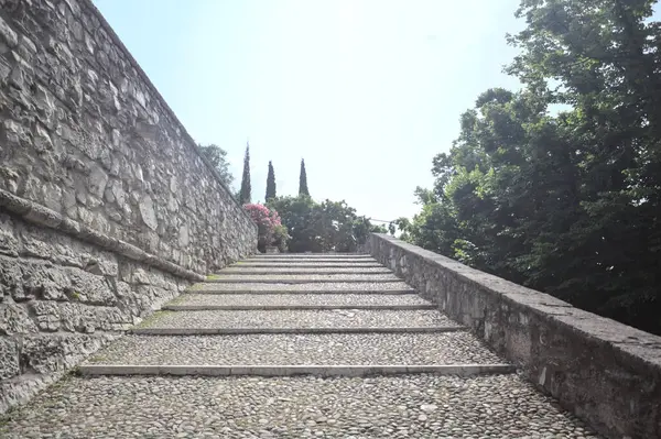 Güneşli bir günde bir kalenin iç duvarına dayanan merdiven.