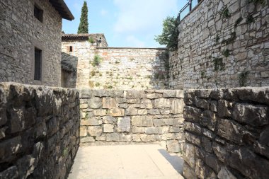 Üzerinde taş bir balkondan görünen bir kalenin iç avlusunu daraltın.