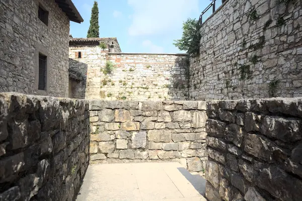 Üzerinde taş bir balkondan görünen bir kalenin iç avlusunu daraltın.