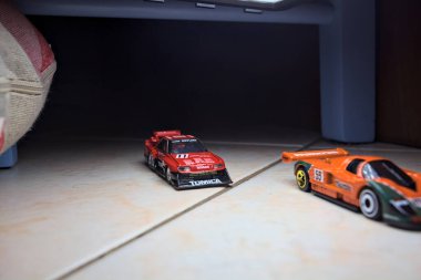 Mantova, İtalya - 14 Haziran 2025 - Mazda 787B 'nin Hot Wheels ve Takara Tomi kopyaları ve bir Nissan GTR Skyline Silhouette tünelin içinde yarışırken