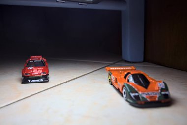 Mantova, İtalya - 14 Haziran 2025 - Mazda 787B 'nin Hot Wheels ve Takara Tomi kopyaları ve bir Nissan GTR Skyline Silhouette tünelin içinde yarışırken