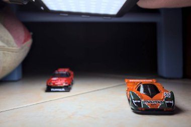 Mantova, İtalya - 14 Haziran 2025 - Mazda 787B 'nin Hot Wheels ve Takara Tomi kopyaları ve bir Nissan GTR Skyline Silhouette tünelin içinde yarışırken