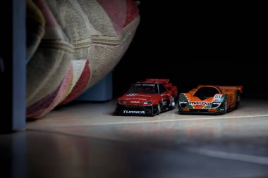 Mantova, İtalya - 14 Haziran 2025 - Mazda 787B 'nin Hot Wheels ve Takara Tomi kopyaları ve bir Nissan GTR Skyline Silhouette tünelin içinde yarışırken