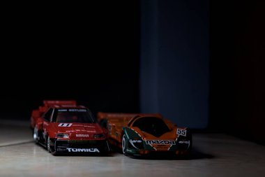 Mantova, İtalya - 14 Haziran 2025 - Mazda 787B 'nin Hot Wheels ve Takara Tomi kopyaları ve bir Nissan GTR Skyline Silhouette tünelin içinde yarışırken