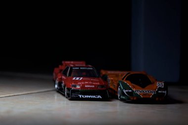 Mantova, İtalya - 14 Haziran 2025 - Mazda 787B 'nin Hot Wheels ve Takara Tomi kopyaları ve bir Nissan GTR Skyline Silhouette tünelin içinde yarışırken