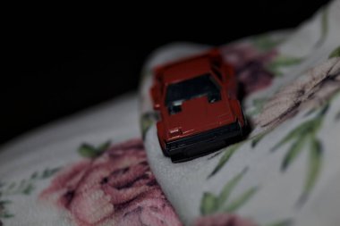 Mantova, İtalya - 14 Haziran 2025 Dar bir dağ yolunda hız yaparken battaniyeye sarılmış 1982 model kırmızı bir Toyota Supra 'nın Sıcak Tekerlekler kopyası