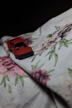 Mantova, İtalya - 14 Haziran 2025 Dar bir dağ yolunda hız yaparken battaniyeye sarılmış 1982 model kırmızı bir Toyota Supra 'nın Sıcak Tekerlekler kopyası