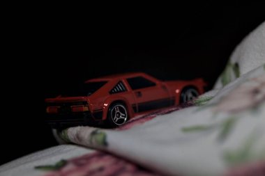 Mantova, İtalya - 14 Haziran 2025 Dar bir dağ yolunda hız yaparken battaniyeye sarılmış 1982 model kırmızı bir Toyota Supra 'nın Sıcak Tekerlekler kopyası