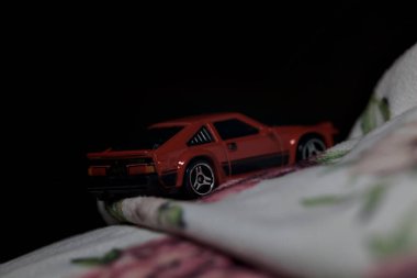 Mantova, İtalya - 14 Haziran 2025 Dar bir dağ yolunda hız yaparken battaniyeye sarılmış 1982 model kırmızı bir Toyota Supra 'nın Sıcak Tekerlekler kopyası