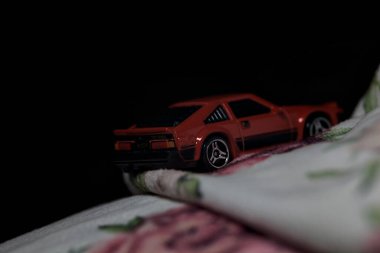 Mantova, İtalya - 14 Haziran 2025 Dar bir dağ yolunda hız yaparken battaniyeye sarılmış 1982 model kırmızı bir Toyota Supra 'nın Sıcak Tekerlekler kopyası