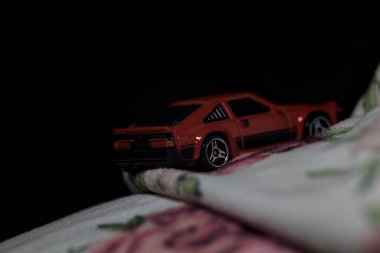 Mantova, İtalya - 14 Haziran 2025 Dar bir dağ yolunda hız yaparken battaniyeye sarılmış 1982 model kırmızı bir Toyota Supra 'nın Sıcak Tekerlekler kopyası