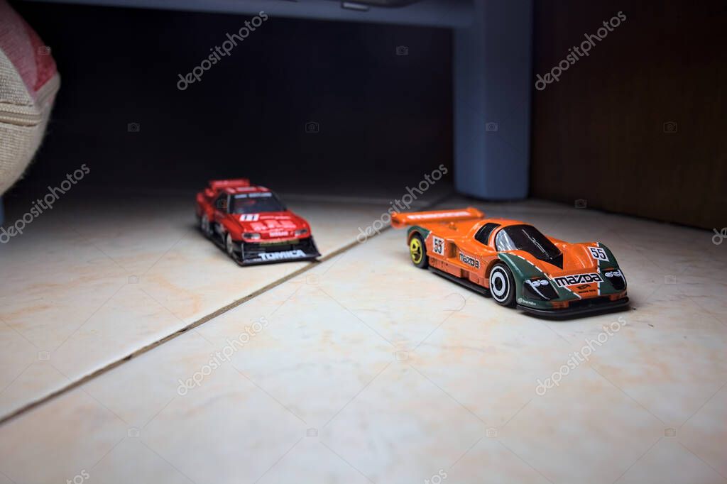 Mantova, Italy - 14TH JUNE 2025 - Hot Wheels and Takara Tomi replicas of a Mazda 787B and a Nissan GTR Skyline Silhouette in the act of racing inside a tunnel