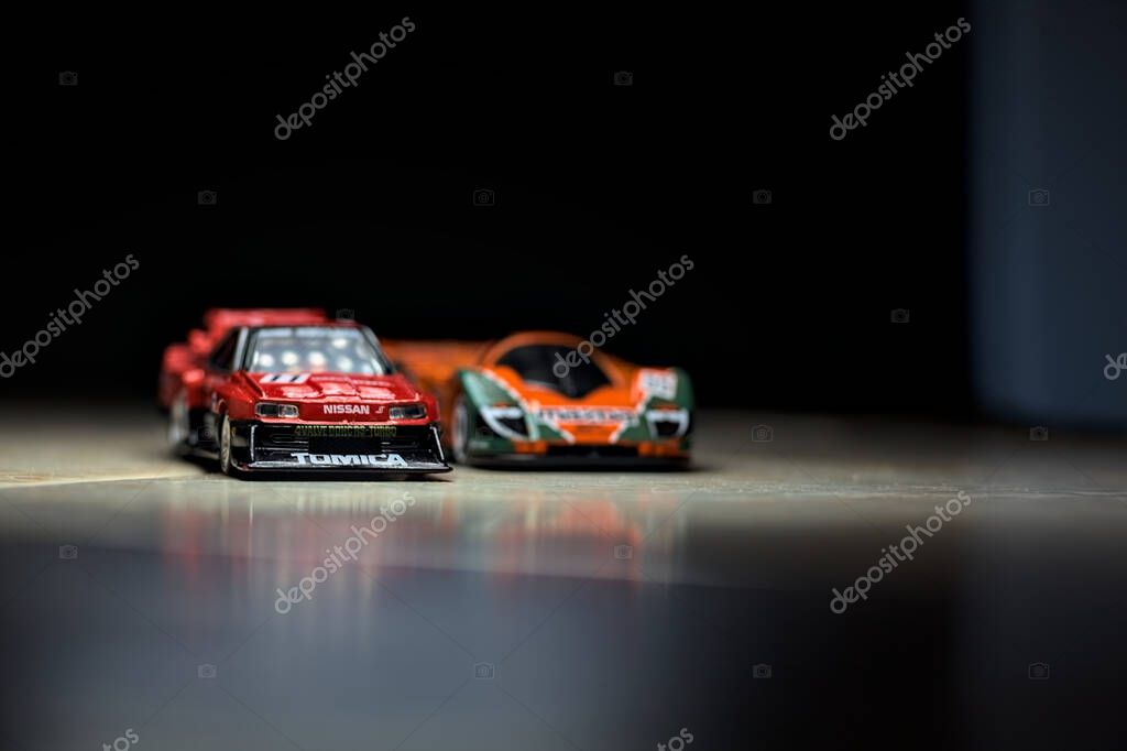 Mantova, Italy - 14TH JUNE 2025 - Hot Wheels and Takara Tomi replicas of a Mazda 787B and a Nissan GTR Skyline Silhouette in the act of racing inside a tunnel