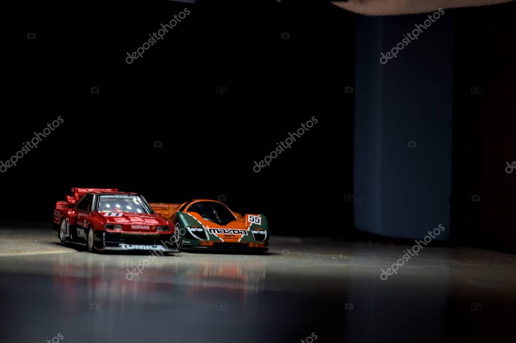Mantova, Italy - 14TH JUNE 2025 - Hot Wheels and Takara Tomi replicas of a Mazda 787B and a Nissan GTR Skyline Silhouette in the act of racing inside a tunnel