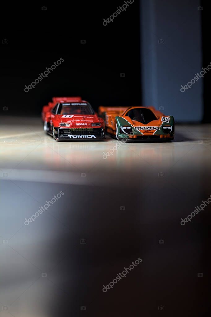 Mantova, Italy - 14TH JUNE 2025 - Hot Wheels and Takara Tomi replicas of a Mazda 787B and a Nissan GTR Skyline Silhouette in the act of racing inside a tunnel