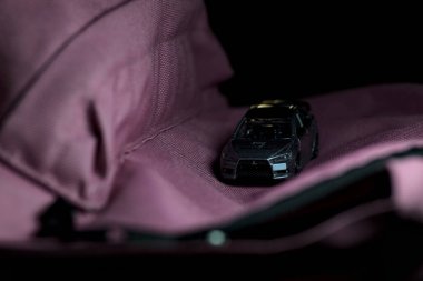 Mantova, İtalya - 11 Haziran 2025 Takara Tomi Mitsubishi 'nin güçlü bir ışık altındaki pembe bir sırt çantasındaki evriminin ralli yarışı varmış gibi görünen kopyası