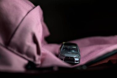 Mantova, İtalya - 11 Haziran 2025 Takara Tomi Mitsubishi 'nin güçlü bir ışık altındaki pembe bir sırt çantasındaki evriminin ralli yarışı varmış gibi görünen kopyası