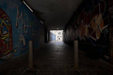 Castel Goffredo, İtalya - 17 Haziran 2025 - Duvarları duvar yazısıyla kaplı bir binanın altındaki sokak