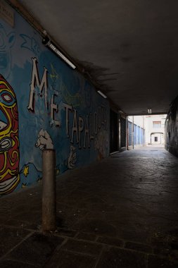 Castel Goffredo, İtalya - 17 Haziran 2025 - Duvarları duvar yazısıyla kaplı bir binanın altındaki sokak