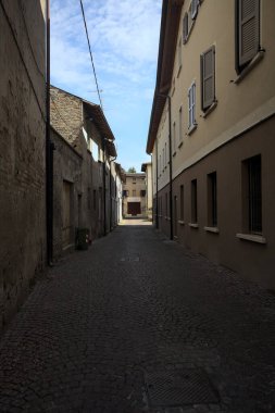 Gölgede, terk edilmiş bir dükkanın sonunda, güneşli bir günde, yolun başındaki bir kemerden görülebilen bir yer.