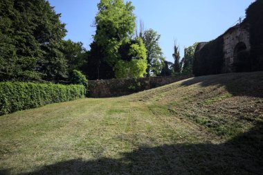Seddin yanında dar bir kapı açıldı ve terk edilmiş bir kalenin bahçesinde gömülü bir köprünün duvarıyla çevrelendi.