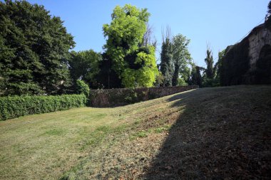 Seddin yanında dar bir kapı açıldı ve terk edilmiş bir kalenin bahçesinde gömülü bir köprünün duvarıyla çevrelendi.