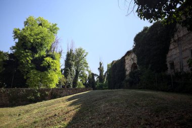 Seddin yanında dar bir kapı açıldı ve terk edilmiş bir kalenin bahçesinde gömülü bir köprünün duvarıyla çevrelendi.