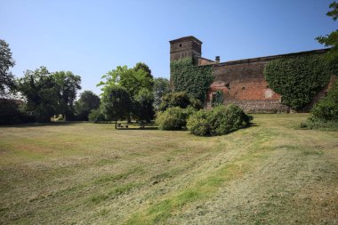 İtalya kırsalında güneşli bir günde bir bahçeden görülen bir şatonun köşesi.