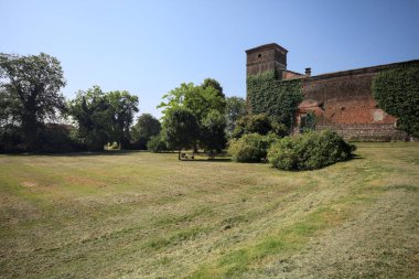 İtalya kırsalında güneşli bir günde bir bahçeden görülen bir şatonun köşesi.